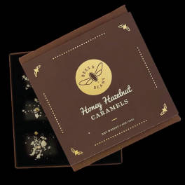 Box of honey hazelnut caramels with a brown lid and black tray