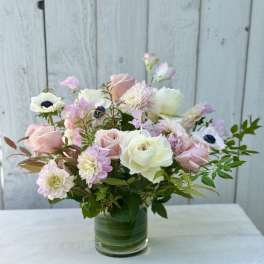 Pastel bouquet of roses and mixed blooms in a clear glass vase