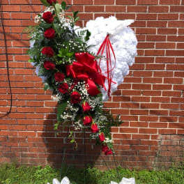 Standing heart-shaped floral tribute with red roses and white flowers