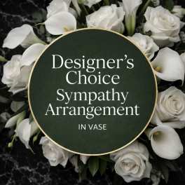White roses and calla lilies arranged around a sympathy sign