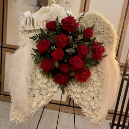 Standing floral wreath with red roses and white chrysanthemums on an easel