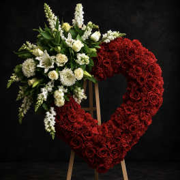 Heart-shaped floral wreath of red and white flowers on an easel