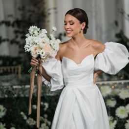 Bride holding a white wedding bouquet with long ribbon streamers