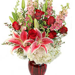 Red roses and pink lilies in a red glass vase