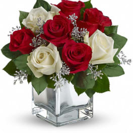 Red and white roses arranged in a clear glass vase