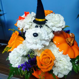 Halloween floral arrangement shaped like a dog with a witch hat and pumpkins