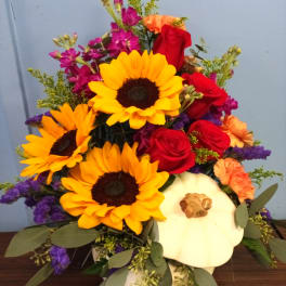 Mixed bouquet with sunflowers, red roses, and a white pumpkin container
