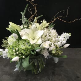 White lily and hydrangea arrangement in a glass vase