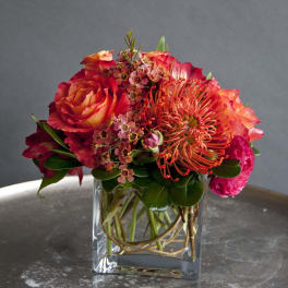 Bouquet of red and orange flowers in a clear glass vase