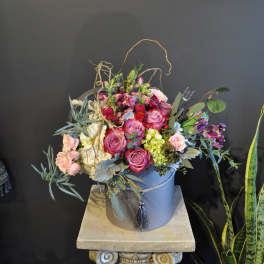 Mixed pink and purple bouquet in a blue hatbox