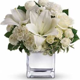 White floral arrangement in a clear square vase