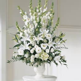 White floral arrangement in a white pedestal vase