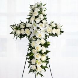 White floral cross wreath on a standing easel