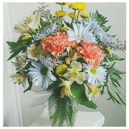 Mixed bouquet of daisies, carnations, and alstroemeria in a glass vase
