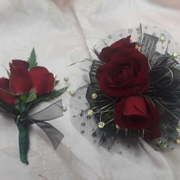 Two burgundy rose floral accessories on white fabric