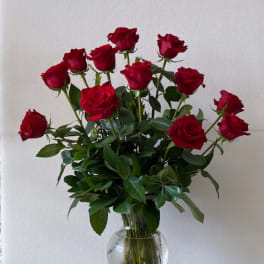 Red roses arranged in a clear glass vase