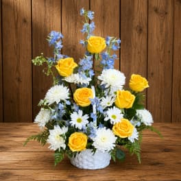 Yellow roses and white daisies in a white basket with blue flowers