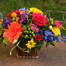 Colorful mixed flower arrangement in a basket on a table