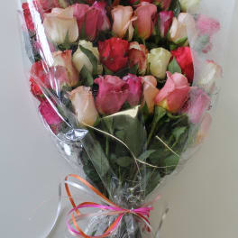 Large mixed-color rose bouquet wrapped in clear plastic with curling ribbons