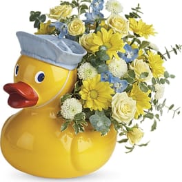 Yellow duck-shaped vase with mixed yellow and blue flowers