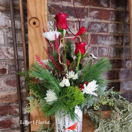 Red roses and white daisies in a birch-print container