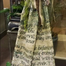 Tall decorative fabric banner with a large striped bow and greenery