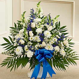 White and blue funeral spray with a blue ribbon