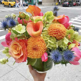 Bright bouquet of orange, pink, and green flowers in a glass vase