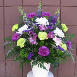 Colorful mixed flower arrangement in a white pot