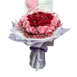 Bouquet of red and pink roses with a glittery heart topper