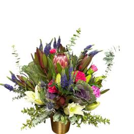 Mixed bouquet with purple, pink, and white flowers in a gold vase