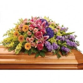 Colorful floral spray on a wooden casket