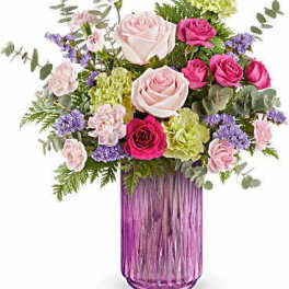 Pink and white rose bouquet in a purple glass vase