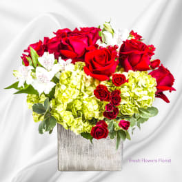 Red roses and white alstroemeria in a square silver vase