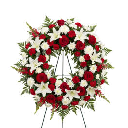 Red and white floral wreath on a stand