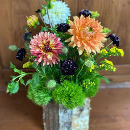 Mixed dahlia arrangement in a rustic wooden container