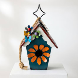 Decorative birdhouse with painted flowers and a rope hanger