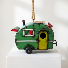 Green decorative birdhouse shaped like a camper with a rope hanger