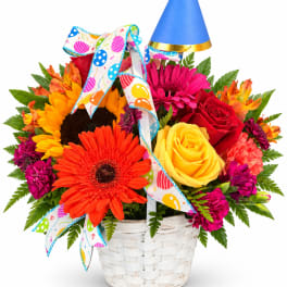 Colorful mixed flower basket with a party hat and ribbon