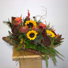 Mixed bouquet with sunflowers and orange roses in a woven basket