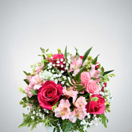 Pink roses and alstroemeria in a square glass vase
