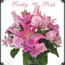 Pink floral arrangement in a glass vase with roses and lilies