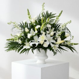 White floral arrangement in a white pedestal vase