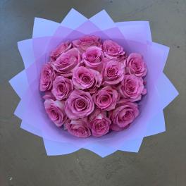 Bouquet of pink roses wrapped in lavender paper