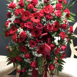 Large red floral standing spray with roses and gerbera daisies