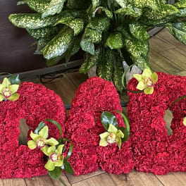 Large red floral letters decorated with yellow orchids