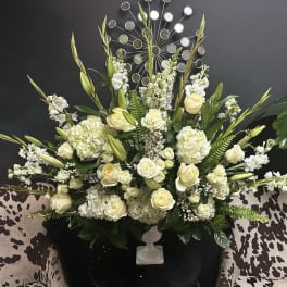 Large white floral arrangement in a white pedestal vase