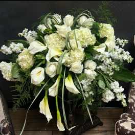 White floral arrangement with calla lilies, roses, and hydrangeas