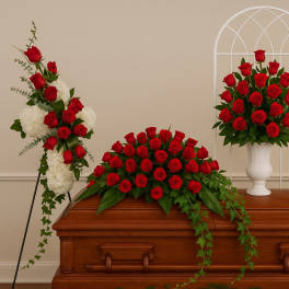 Red rose funeral sprays arranged around a casket