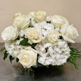 White roses and hydrangeas arranged in a low black container